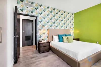 a bedroom with a large bed and a green wall at Costa Hollywood - Worth Traveling - Rooftop Pool- Gym in Hollywood