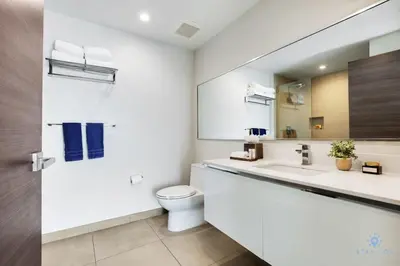 a white bathroom with a toilet and a sink at Bay View - Balcony - Amazing Pool - Hollywood Beach in Hollywood