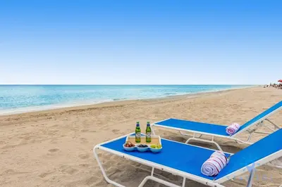 a picnic table on the beach with bottles of beer at Amazing Pool - Hot Tub - Gym - Hollywood Beach in Hollywood