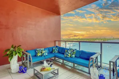 a living room with a blue couch and a view of the ocean at Amazing Pool - Hot Tub - Gym - Hollywood Beach in Hollywood