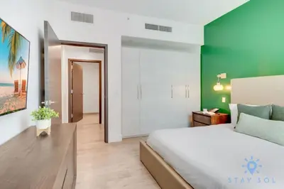 a bedroom with a large bed and a green wall at Lx Oasis Beachfront-Rt infinity POOL in Hollywood