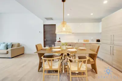 a kitchen and dining room with a wooden table and chairs at Rooftop Pool & Hot Tub - Gym - Hollywood Beach in Hollywood