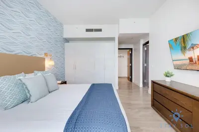 a bedroom with a large bed with a blue blanket at Rooftop Pool & Hot Tub - Gym - Hollywood Beach in Hollywood