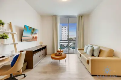 a living room with a couch and a desk at Rooftop Pool & Hot Tub - Gym - Hollywood Beach in Hollywood