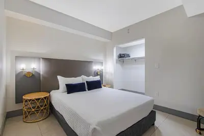 a bedroom with a large white bed with blue pillows at Roami at Habitat Brickell in Miami