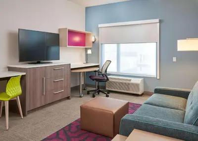 a living room with a couch and a desk with a tv at Home2 Suites By Hilton Ft. Lauderdale Downtown, Fl in Fort Lauderdale