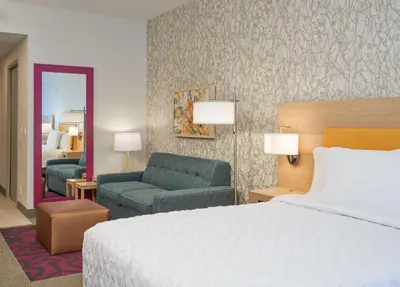 a hotel room with a bed and a living room at Home2 Suites By Hilton Ft. Lauderdale Downtown, Fl in Fort Lauderdale