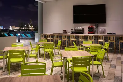 a restaurant with tables and chairs and a bar at Tru By Hilton Fort Lauderdale Downtown-Flagler Village in Fort Lauderdale
