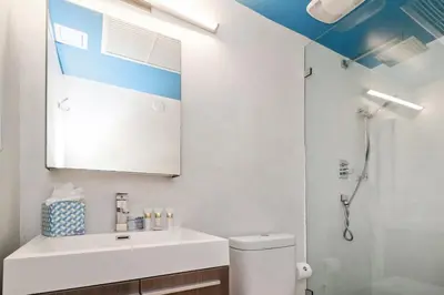 a bathroom with a white sink and a shower at Roami at 250 Collins in Miami Beach