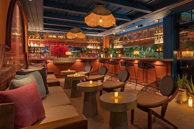 a restaurant with tables and chairs and a bar at Moxy Miami South Beach in Miami Beach