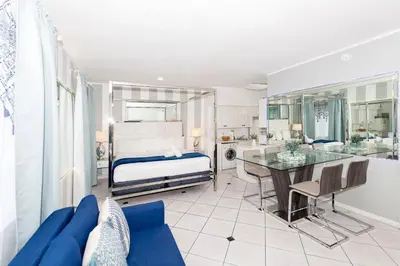 a bedroom with a bed and a table in a room at Apartments on Collins in Miami Beach