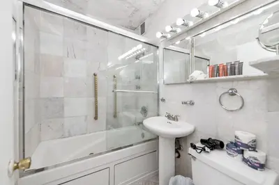 a white bathroom with a sink and a shower at Apartments on Collins in Miami Beach