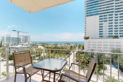 a balcony with chairs and a table and a view of the ocean at Paradise Perch in Fort Lauderdale