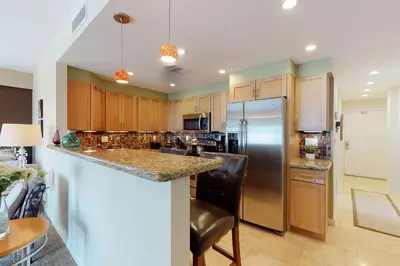 a kitchen with wooden cabinets and stainless steel appliances at Paradise Perch in Fort Lauderdale