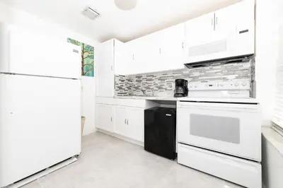 a white kitchen with white appliances and white cabinets at Apartments on Ocean Drive in Miami Beach