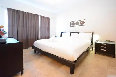 a bedroom with a large bed and a dresser with a night stand at Apartments on Ocean Drive in Miami Beach