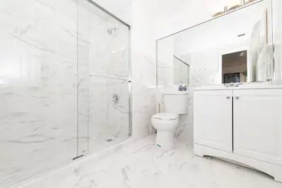 a white bathroom with a shower and a toilet at Apartments on Ocean Drive in Miami Beach