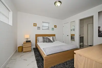 a white bedroom with a bed and a night stand at Relax and enjoy Fort Lauderdale beach! in Fort Lauderdale