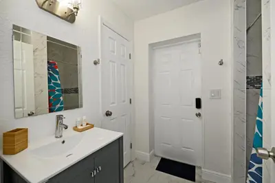 a white bathroom with a sink and a mirror at Relax and enjoy Fort Lauderdale beach! in Fort Lauderdale