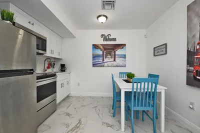 a kitchen with a table and two blue chairs at Relax and enjoy Fort Lauderdale beach! in Fort Lauderdale