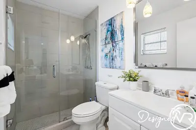 a bathroom with a shower and a toilet and a sink at 4BR retreat w heated pool backyard BBQ grill in Dania Beach