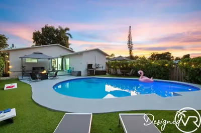 a swimming pool in the backyard of a house at 4BR retreat w heated pool backyard BBQ grill in Dania Beach