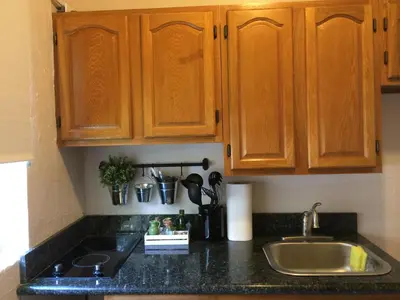 a kitchen counter with wooden cabinets and a sink at Cozy Studio near Coconut Grove in Miami