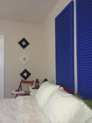 a bedroom with a bed and a blue shutter door at Chic and Comfortable Studio Free Street Parking in Miami