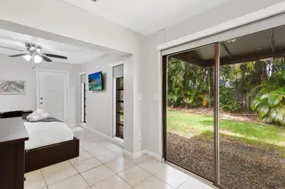 a bedroom with a bed and a sliding glass door at The Home in The Oaks - By Avi in Fort Lauderdale