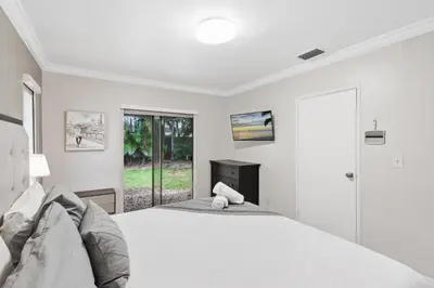 a white bedroom with a bed and a window at The Home in The Oaks - By Avi in Fort Lauderdale