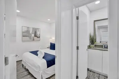a white bedroom with a bed and a mirror at Cozy studio wbeach boardwalk steps kitchen in Hollywood