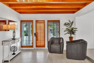 a living room with a chair and a table at Family home wpool tiki hut grill in Hollywood