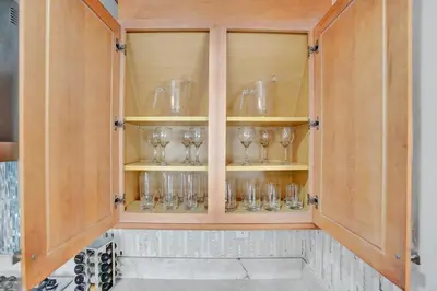 a cabinet with wine glasses in it at Family home wpool tiki hut grill in Hollywood