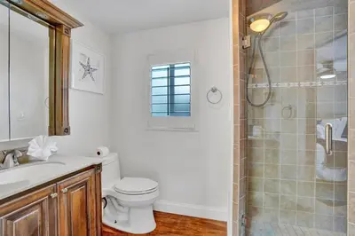a white bathroom with a toilet and a shower at Family home wpool tiki hut grill in Hollywood