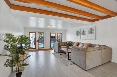 a living room with two couches and a plant at Family home wpool tiki hut grill in Hollywood