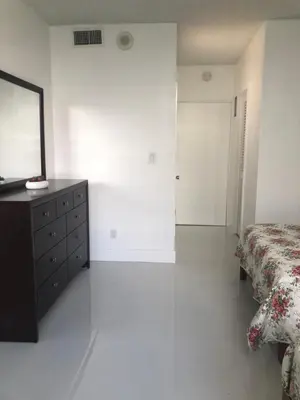 a bedroom with a bed and a dresser and a mirror at The Blue Island in Miami Beach