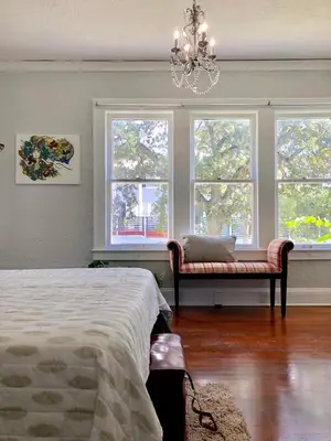 a bedroom with windows and a bed and a chandelier at Comfy and Spacious Suite with Free Parking in Miami