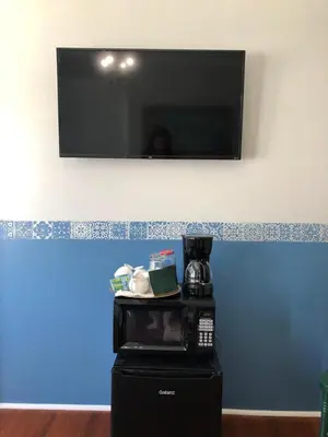 a tv hanging on a wall above a microwave at Comfy and Spacious Suite with Free Parking in Miami