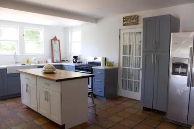 a kitchen with blue cabinets and a white refrigerator at Comfy and Spacious Suite with Free Parking in Miami