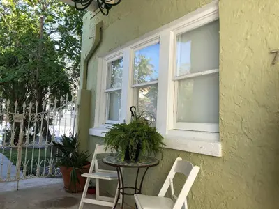 a table and chairs on a porch with two windows at Cozy Aqua Private Suite with Parking in Miami