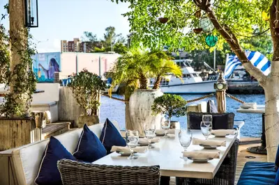 a table with chairs and wine glasses on a patio at Sunny and Charming Suite next to MIA in Miami