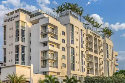 a rendering of a building with palm trees at Courtyard by Marriott Fort Lauderdale Downtown in Fort Lauderdale