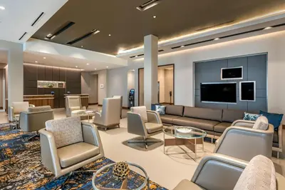 a lobby with a couch and chairs and a tv at Courtyard by Marriott Fort Lauderdale Downtown in Fort Lauderdale