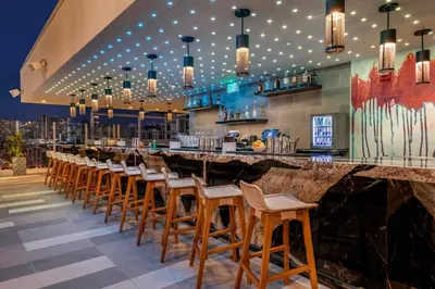 a bar with a row of wooden stools at Courtyard by Marriott Fort Lauderdale Downtown in Fort Lauderdale