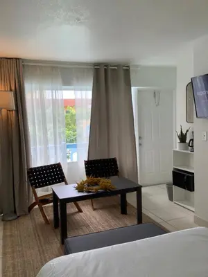 a living room with a couch and a table and chairs at Hotel Motel Lauderdale Inn in Fort Lauderdale