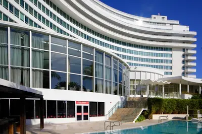 an office building with a pool in front of it at FB Miami Beach Tresor Private Luxury Suites in Miami Beach
