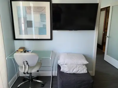 a room with a desk and a chair and a tv at VERSACE MANSION VIEW SUITE at THE STRAND in Miami Beach