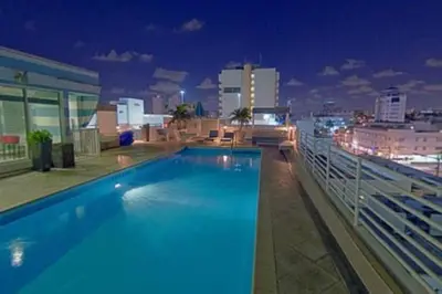 a swimming pool on top of a building at night at VERSACE MANSION VIEW SUITE at THE STRAND in Miami Beach