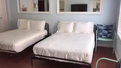 a room with two beds and a tv and mirrors at 918 SOBE FLATS in Miami Beach