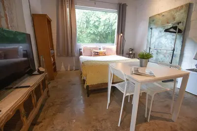 a living room with a bed and a table and a television at Casa Coral in Miami